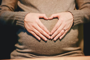 Pregnant woman making heart symbol