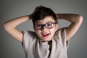 child with palsy smiling at camera